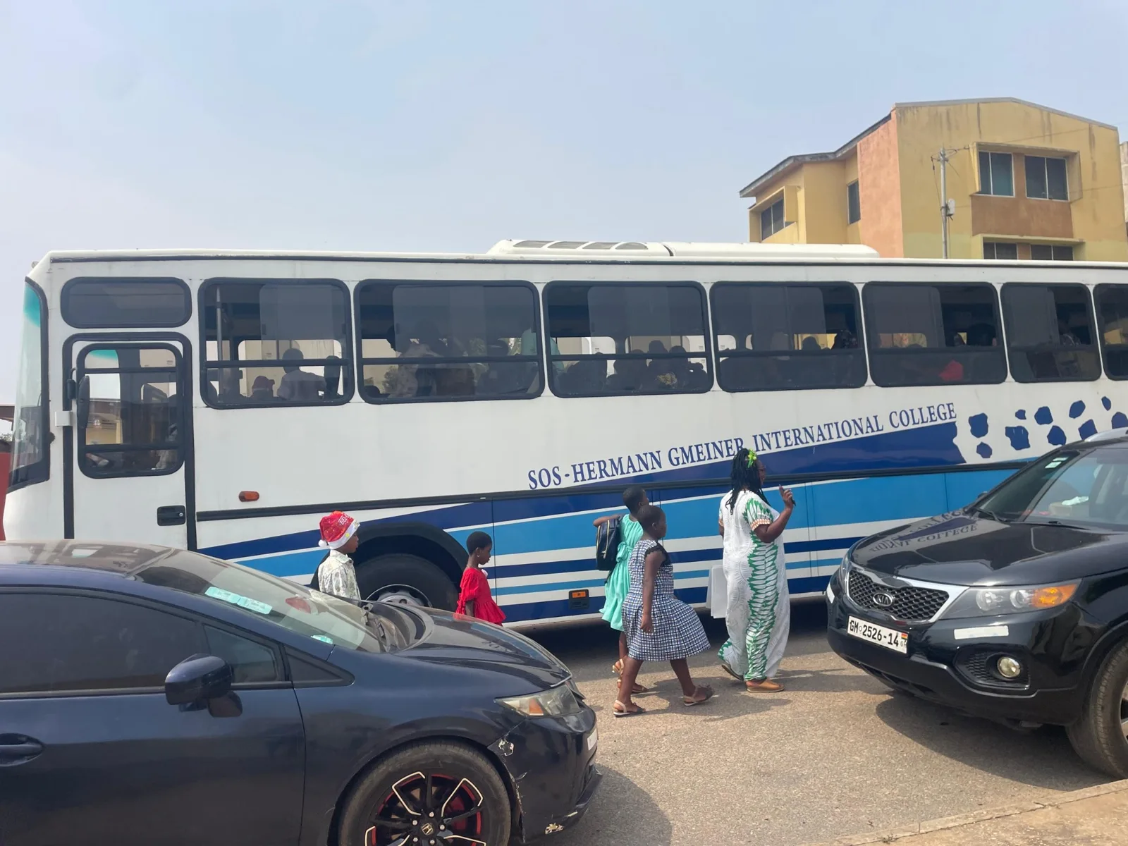 A bus and parked vehicles outside the event area.