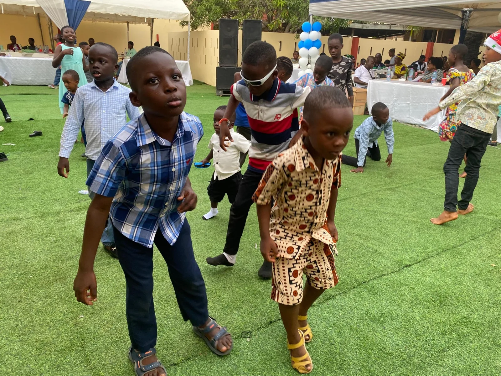 Children dancing together on the lawn.